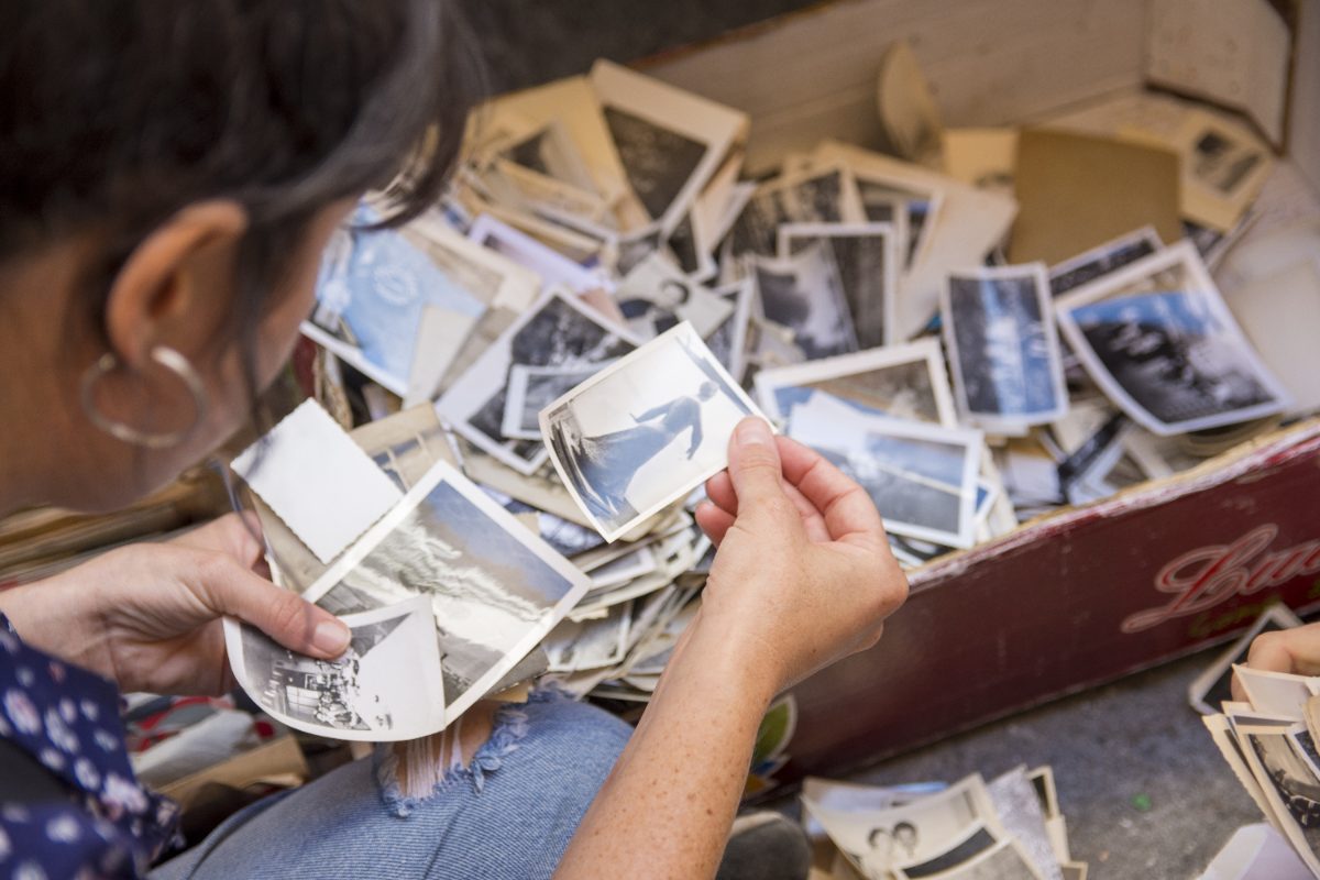 Hands looking through a box of treasured old family photographs